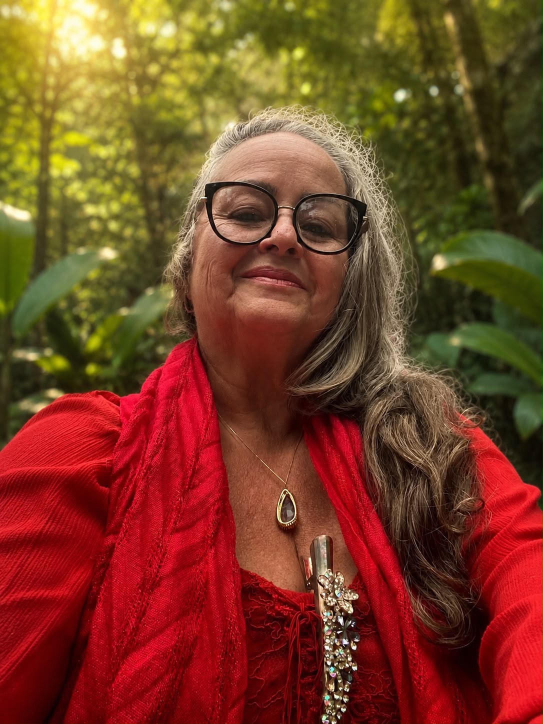 Cristina Melgaço vestida de vermelho em meio à natureza